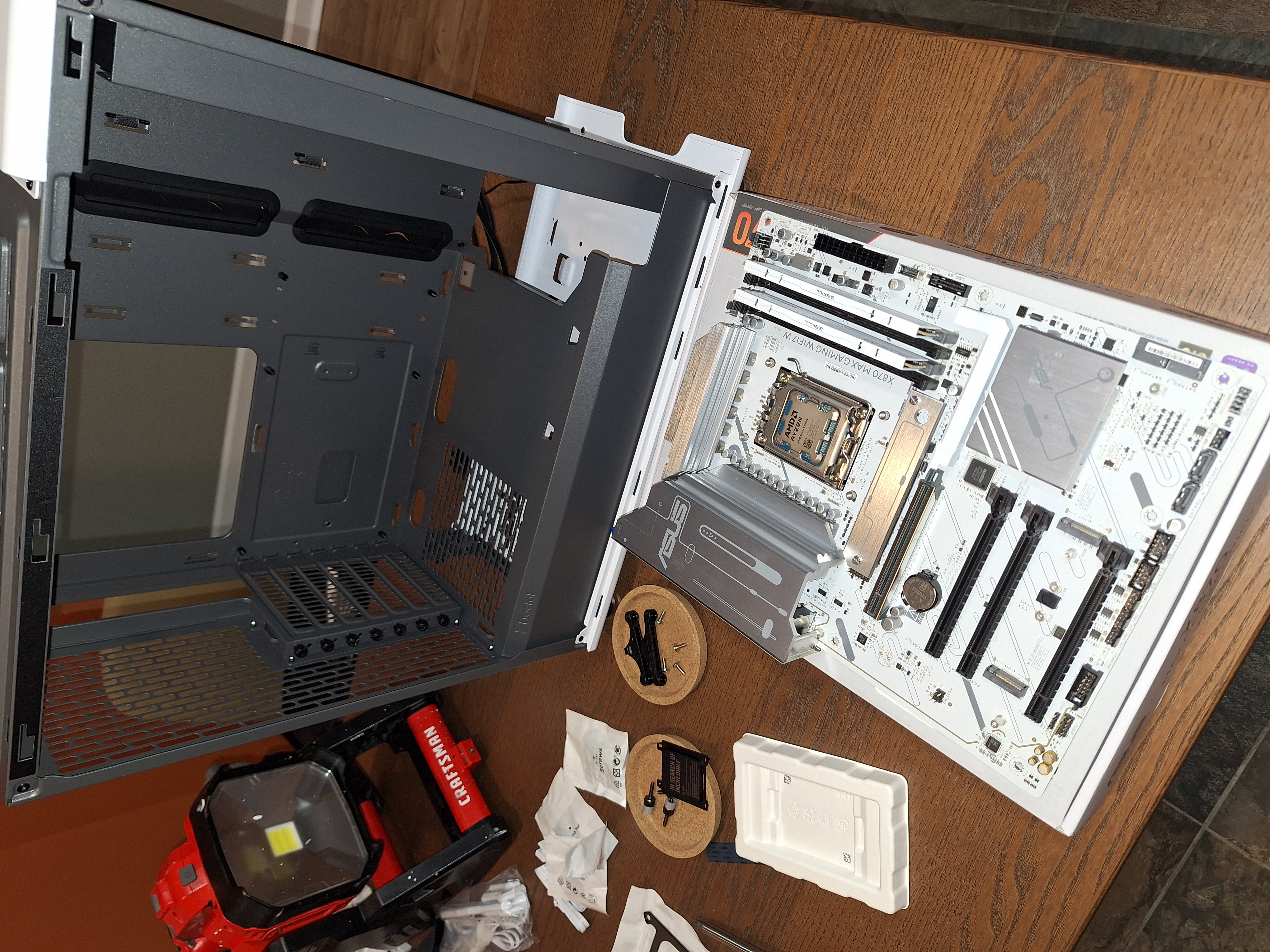 Asus motherboard with the Ryzen processor and memory installed beside the empty case